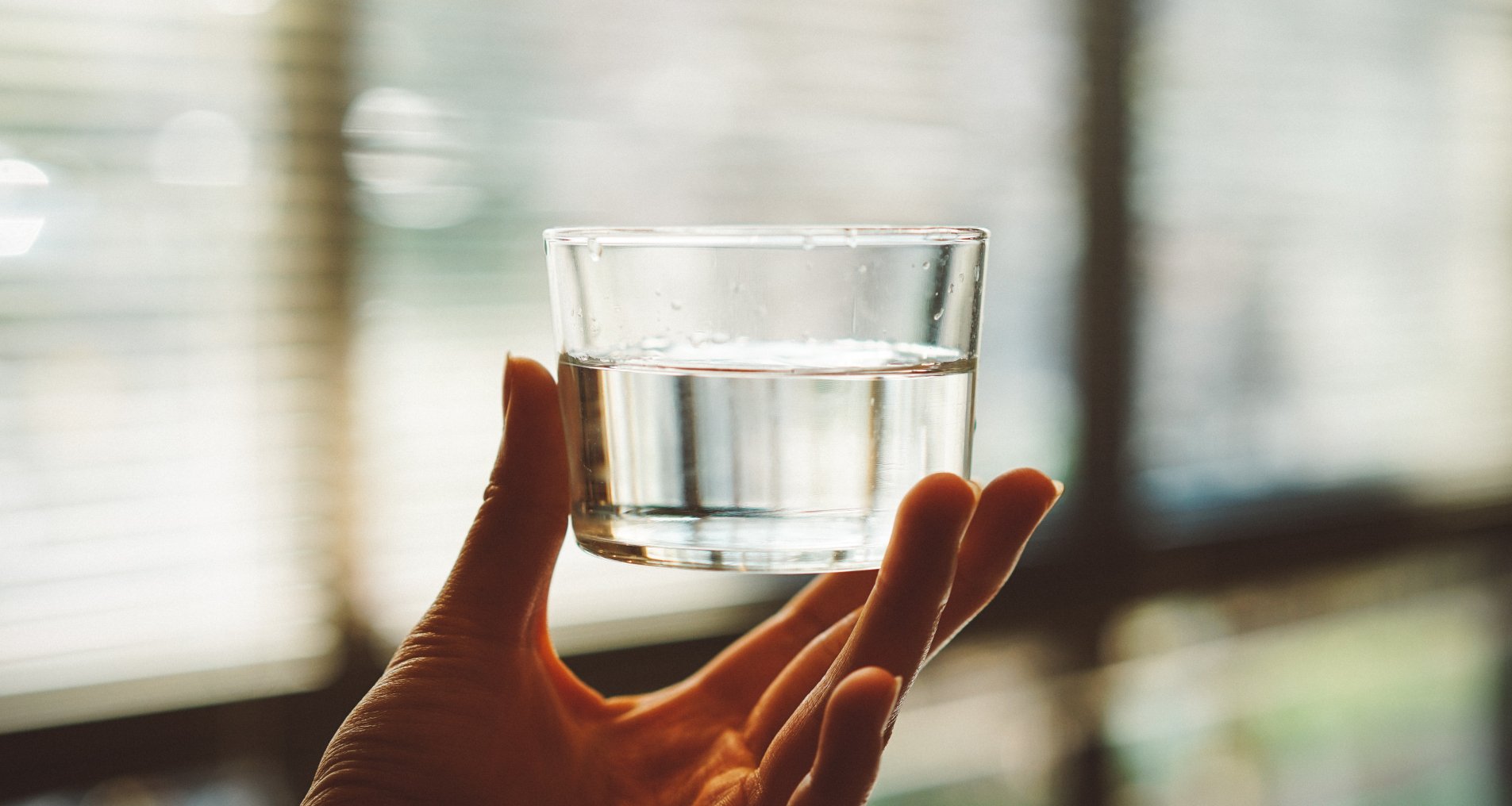 Женщина, держащая стакан с водой